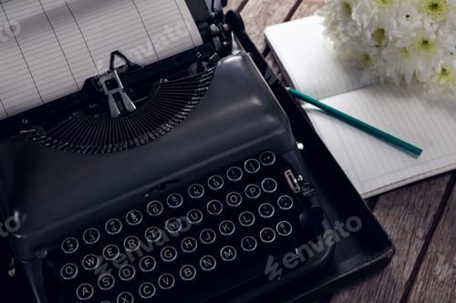 Preview: Close-Up Of Vintage Typewriter, Diary And Flowers On Wooden Table