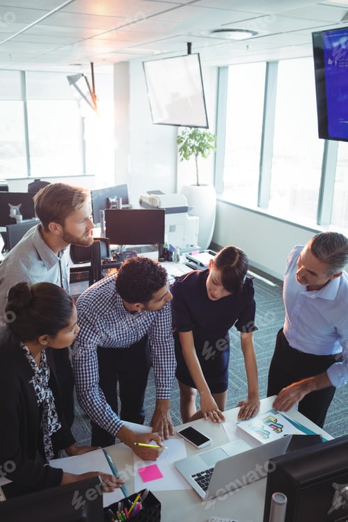 Preview: High Angle View Of Business Colleagues Working At Office Desk