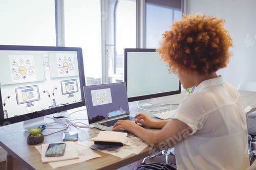 Preview: Focused Businesswoman Working On Laptop In Office