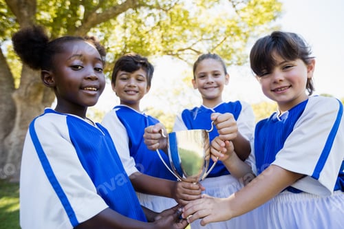 Preview: Happy Children Soccer Team Holding Cup In Park