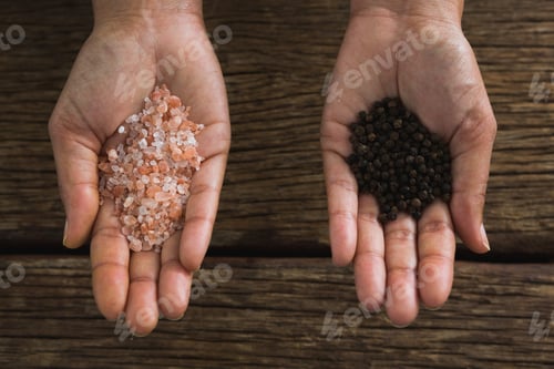 Preview: Close-Up Of Hands Holding Sea Salt And Black Pepper Seeds