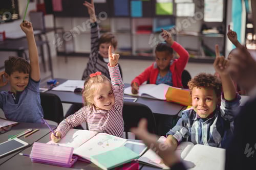 Preview: Schoolkids Raising Their Hands In Classroom At School
