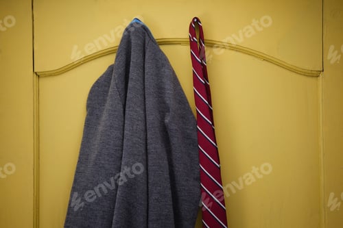 Preview: Close-Up Of School Uniform Hanging On Yellow Door