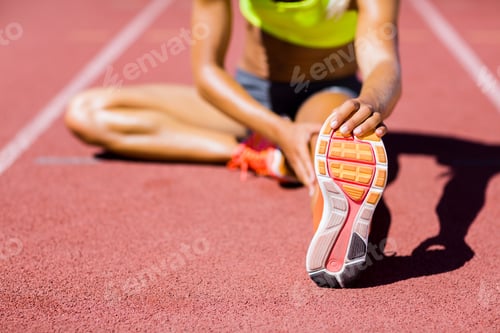 Preview: Female Athlete Warming Up On The Running Track On A Sunny Day