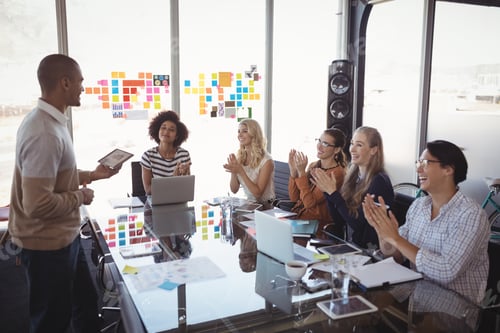 Preview: Business People Applauding For Colleague Giving Presentation In Office