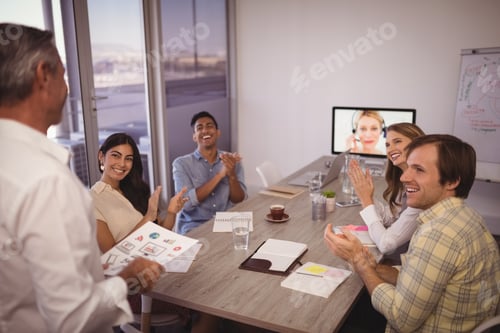 Preview: Colleagues Applauding For Mature Businessman Giving Presentation In Conference Room