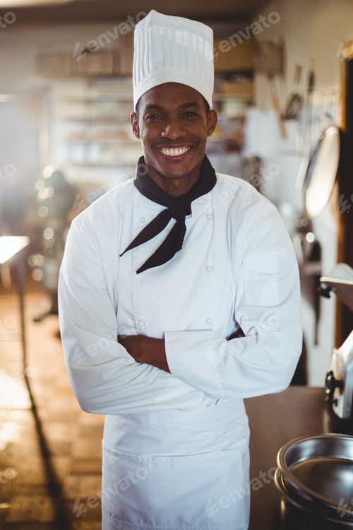 Preview: Portrait Of Smiling Chef Standing With Arms Crossed In Commercial Kitchen
