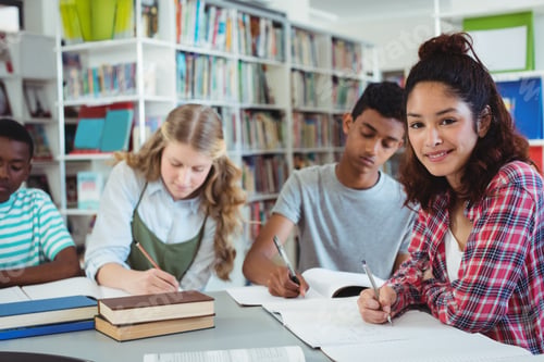 Preview: Portrait Of Happy Schoolgirl Studying With Her Classmates In Library At School