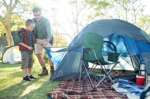Preview: Father And Son Setting Up The Tent At Campsite On A Sunny Day