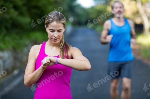 Preview: Fit Woman Checking Time On Wristwatch After Jogging