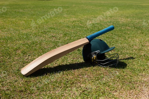 Preview: High Angle View Of Cricket Bat And Helmet On Field During Sunny Day