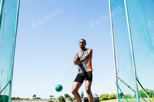 Preview: Determined Athlete Performing A Hammer Throw In Stadium