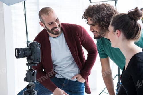 Preview: Photographer Reviewing Captured Photos In His Digital Camera At Studio