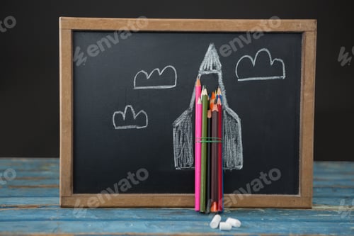 Preview: Close-Up Of Picture On Slate With Color Pencils On Table