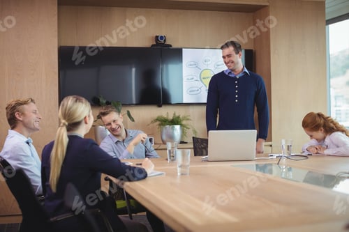 Preview: Happy Business Colleagues Discussing During Meeting In Board Room
