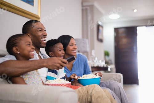 Preview: Cheerful Family Having Popcorn While Watching Television At Home