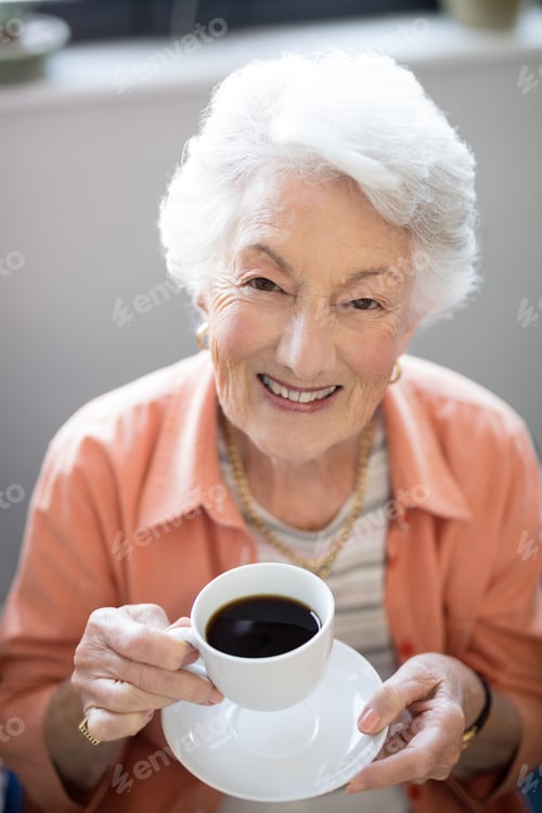 Preview: High Angle Portrait Of Senior Woman Holding Coffee Cup At Nursing Home