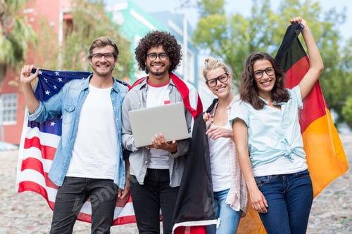 Preview: Group Of Happy Friends Holding National Flag And Using Laptop