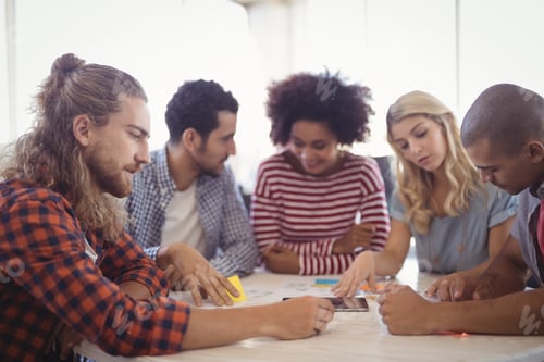 Preview: Young Businessman Sitting With Colleagues At Office Desk