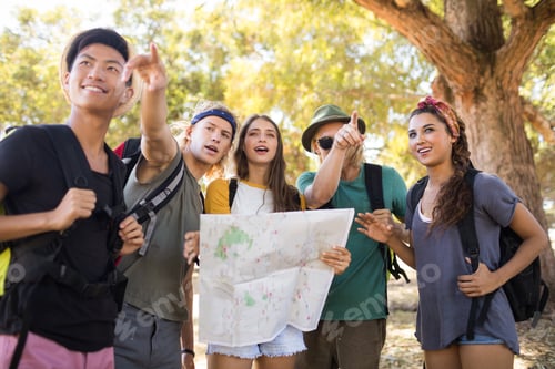 Preview: Friends With Map Gesturing While Standing On Field