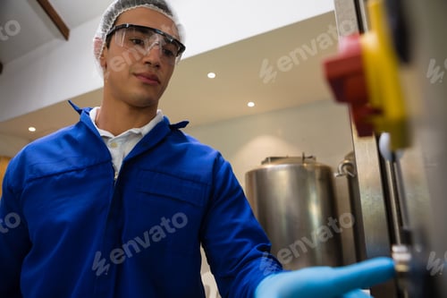 Preview: Male Worker Pressing Button Of Machinery At Warehouse
