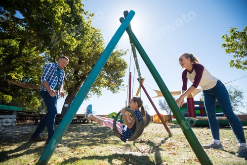 Preview: Happy Mother Swinging Daughter At Playground Against Sky