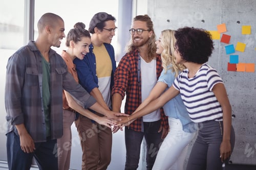 Preview: Group Of Cheerful Business People Stacking Hands In Creative Office