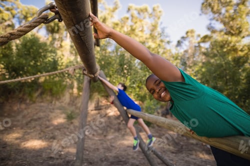 Preview: Portrait Of Happy Boy Exercising On Outdoor Equipment During Obstacle Course In Boot Camp