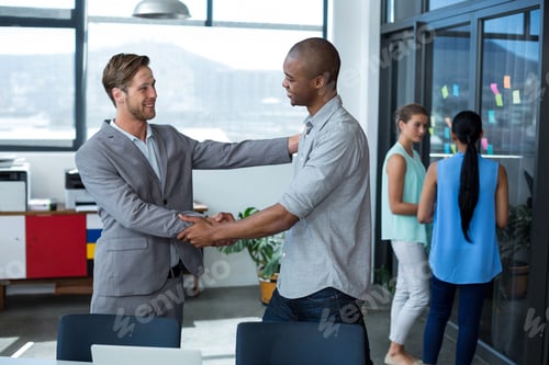 Preview: Smiling Business Executives Shaking Hands In Office