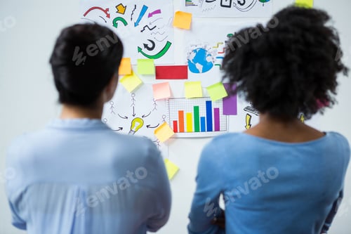 Vista previa: Rear View Of Female Graphic Designers Looking At The White Board