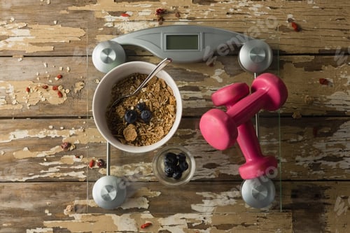Preview: Overhead View Of Bowl Of Breakfast And Dumbbells On Weighing Scale