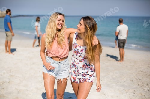 Preview: Happy Female Friends With Arm Around Walking On Shore At Beach