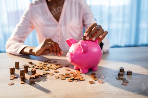Preview: Woman Putting Money In A Piggy Bank