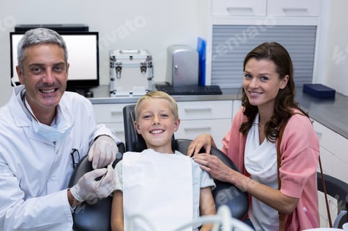 Visualização: Retrato de dentista com jovem paciente e sua mãe na clínica odontológica