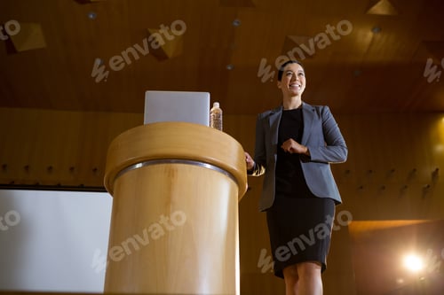 Preview: Female Business Executive Giving A Speech At Conference Center