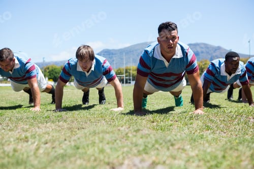 Preview: Rugby Players Doing Push Up On Field Against Clear Sky