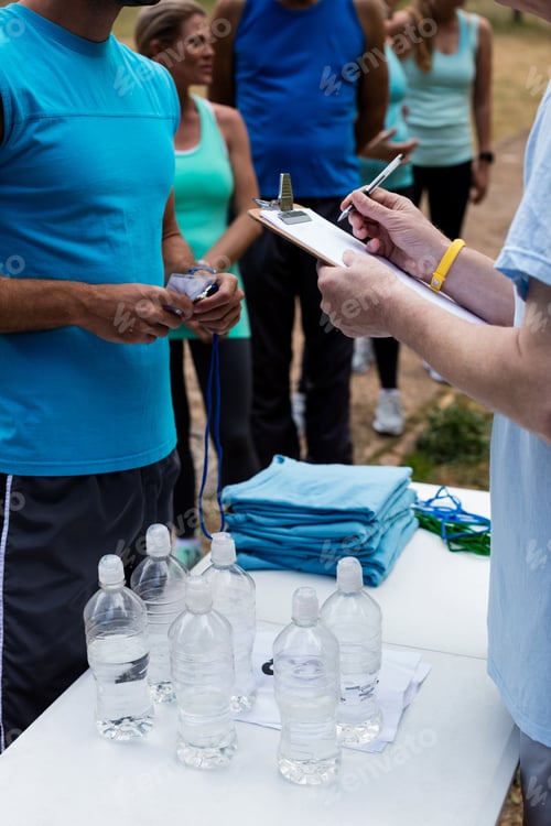 Preview: Mid Section Of Volunteer Registering Athletes Name For Race In Park