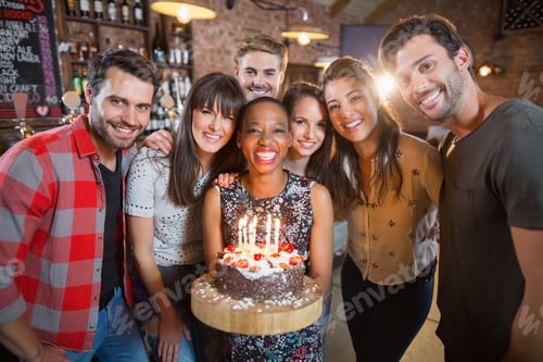 Visualização: Retrato de amigos felizes segurando bolo de aniversário no restaurante