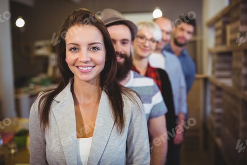 Preview: Portrait Of Confident Young Businesswoman With Colleagues Standing In Row At Creative Office
