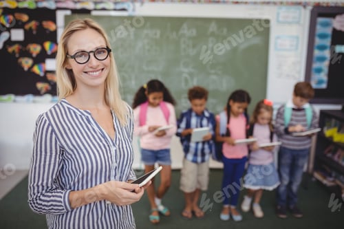 Visualização: Retrato de um professor feliz em pé segurando um tablet digital com alunos em segundo plano