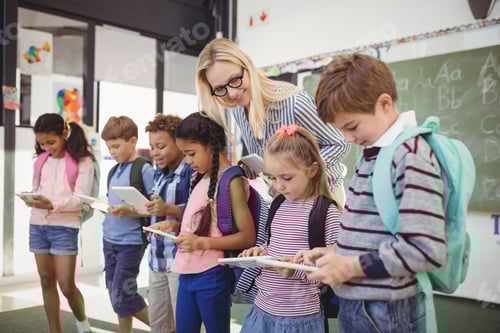 Visualização: Professor auxiliando crianças em idade escolar em tablet digital em sala de aula na escola
