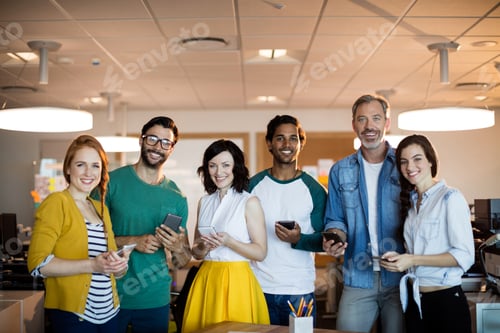Preview: Portrait Of Smiling Creative Business Team Using Mobile Phone In Office