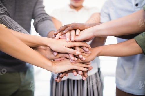 Preview: Close Up Of Colleagues Stacking Hands While Standing In Office
