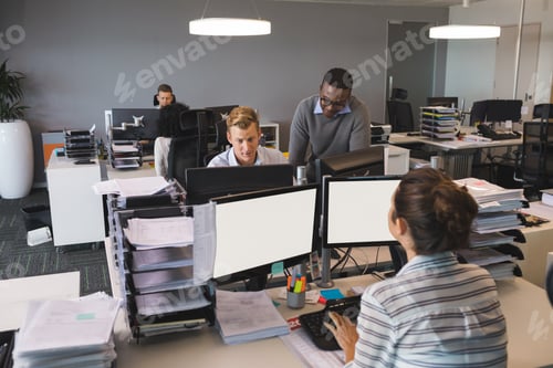 Preview: Business Colleagues Working On Computers At Desk In Office
