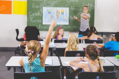 Preview: School Girl Raising Hand In Classroom At School