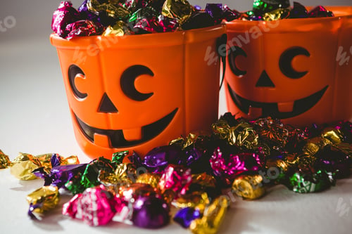 Preview: Close Up Of Orange Buckets With Multicolored Chocolates Over White Background