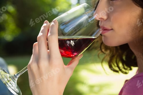 Preview: Close-Up Of Woman Drinking Glass Of Red Wine In Park
