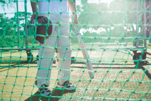 Preview: Low Section Of Crickter Standing By Net At Field On Sunny Day