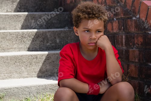 Preview: Upset Boy Sitting On Staircase In The Boot Camp On A Sunny Day