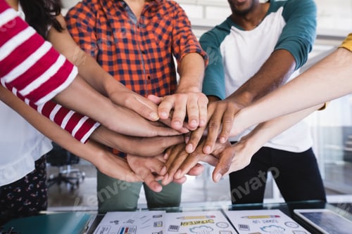 Preview: Close Up Of Business People Stacking Hands While Standing In Board Room